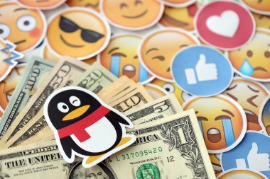 KYIV, UKRAINE - 20 Nisan 2024 Tencent QQ logosu ve pek çok kullanıcı para faturası. Birçok emoji reaksiyonuna ilişkin ünlü sosyal ağ platformu ve dolar banknotlarının sembolü