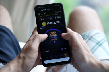 KYIV, UKRAINE - 20 Nisan 2024 Hamster Kombat telgraf robotu akıllı telefon ekranında. Hamster Kombat, sanal bir şifreleme takası ile HMSTR jetonları kazanmak için kullanılan bir viral Telegram tabanlı şifreleme oyunudur.