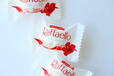 KYIV, UKRAINE - 20 Nisan 2024 Ferrero Raffaello premium tatlılar İtalyan çikolata üreticisi Ferrero SpA tarafından beyaz arka planda üretildi. Raffaello şekerlemeleri küresel bir hindistan cevizi badem şekerlemesidir.