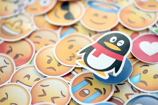 stock image KYIV, UKRAINE - APRIL 20, 2024 Tencent QQ logo and large set of stickers with Emoji yellow faces. Emoji is a pictogram or smiley embedded in text and used in electronic messages and web pages