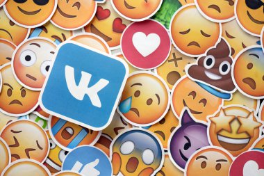 KYIV, UKRAINE - 20 Nisan 2024 VK logosu ve Emoji sarı yüzlü büyük çıkartmalar. Emoji, elektronik mesajlarda ve web sayfalarında kullanılan ve metne gömülü bir resim veya gülen yüzdür.