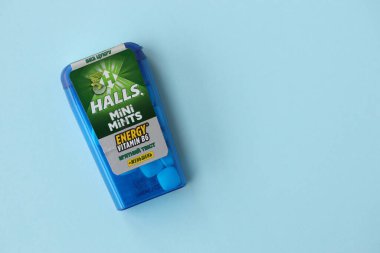 KYIV, UKRAINE - 20 Nisan 2024 Halls Mini nane şekeri bükülmüş enerji vitamini b6 küçük mavi kutu içinde sert nane şekerleri mavi arka planda yakın plan
