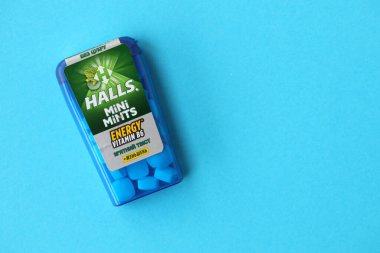 KYIV, UKRAINE - 20 Nisan 2024 Halls Mini nane şekeri bükülmüş enerji vitamini b6 küçük mavi kutu içinde sert nane şekerleri mavi arka planda yakın plan