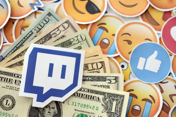 KYIV, UKRAINE - 20 Nisan, 2024 Twitch logosu ve birçok kullanım parası. Birçok emoji reaksiyonuna ilişkin ünlü sosyal ağ platformu ve dolar banknotlarının sembolü