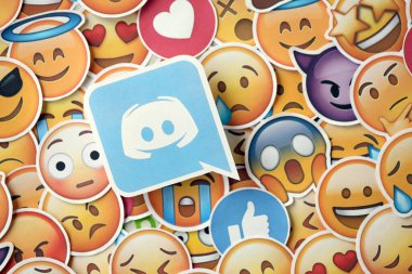 KYIV, UKRAINE - 20 Nisan 2024 Discord logosu ve Emoji sarı yüzlü büyük çıkartmalar. Emoji, elektronik mesajlarda ve web sayfalarında kullanılan ve metne gömülü bir resim veya gülen yüzdür.