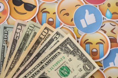 KYIV, UKRAINE - 20 Nisan 2024 dolar para ve Emoji sarı yüzlü büyük çıkartmalar. Sm kavramı, smo sosyal medyada yükseltmek için ödeme yaptı. Geribildirim ve ödenmiş sahte tepkiler