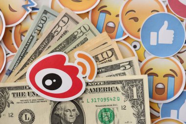 KYIV, UKRAINE - 20 Nisan, 2024 Weibo logosu ve birçok kullanım parası. Birçok emoji reaksiyonuna ilişkin ünlü sosyal ağ platformu ve dolar banknotlarının sembolü