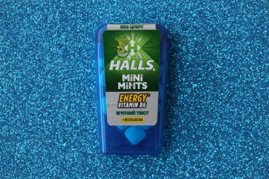 KYIV, UKRAINE - 20 Nisan 2024 Halls Mini nane şekeri bükülmüş enerji vitamini b6 küçük mavi kutu içinde sert nane şekerleri mavi arka planda yakın plan