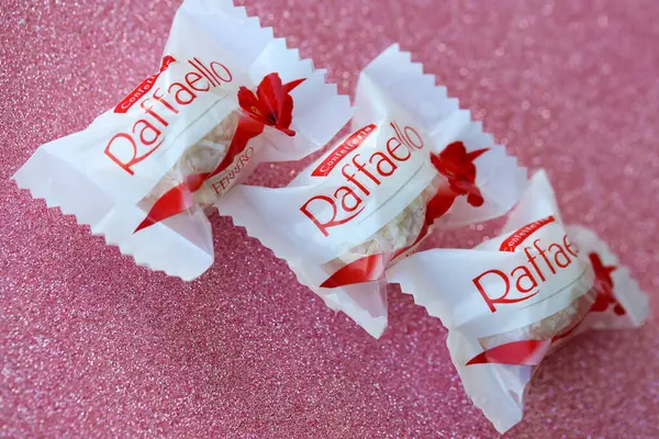 Stock image KYIV, UKRAINE - APRIL 20, 2024 Ferrero Raffaello premium sweets produced by the Italian chocolatier Ferrero SpA on a pink background. Raffaello candies is a spherical coconut almond confection