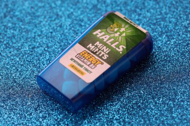KYIV, UKRAINE - 20 Nisan 2024 Halls Mini nane şekeri bükülmüş enerji vitamini b6 küçük mavi kutu içinde sert nane şekerleri mavi arka planda yakın plan