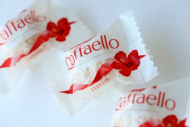 KYIV, UKRAINE - 20 Nisan 2024 Ferrero Raffaello premium tatlılar İtalyan çikolata üreticisi Ferrero SpA tarafından beyaz arka planda üretildi. Raffaello şekerlemeleri küresel bir hindistan cevizi badem şekerlemesidir.