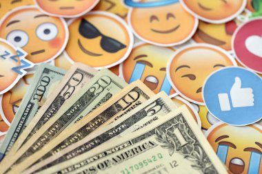 KYIV, UKRAINE - 20 Nisan 2024 dolar para ve Emoji sarı yüzlü büyük çıkartmalar. Sm kavramı, smo sosyal medyada yükseltmek için ödeme yaptı. Geribildirim ve ödenmiş sahte tepkiler