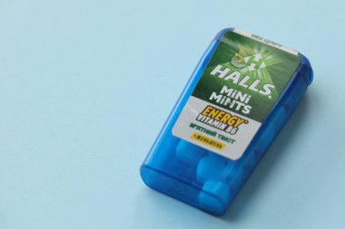 KYIV, UKRAINE - 20 Nisan 2024 Halls Mini nane şekeri bükülmüş enerji vitamini b6 küçük mavi kutu içinde sert nane şekerleri mavi arka planda yakın plan