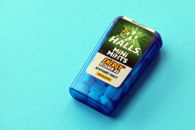 KYIV, UKRAINE - 20 Nisan 2024 Halls Mini nane şekeri bükülmüş enerji vitamini b6 küçük mavi kutu içinde sert nane şekerleri mavi arka planda yakın plan