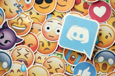 KYIV, UKRAINE - 20 Nisan 2024 Discord logosu ve Emoji sarı yüzlü büyük çıkartmalar. Emoji, elektronik mesajlarda ve web sayfalarında kullanılan ve metne gömülü bir resim veya gülen yüzdür.