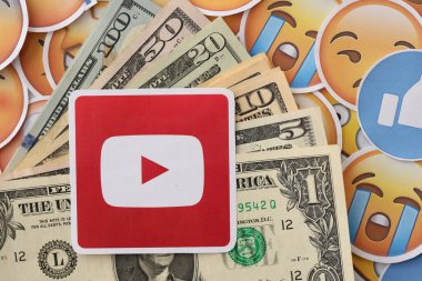 KYIV, UKRAINE - 20 Nisan 2024 YouTube logosu ve birçok kullanım dışı para. Birçok emoji reaksiyonuna ilişkin ünlü sosyal ağ platformu ve dolar banknotlarının sembolü