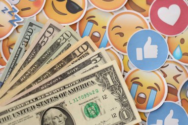 KYIV, UKRAINE - 20 Nisan 2024 dolar para ve Emoji sarı yüzlü büyük çıkartmalar. Sm kavramı, smo sosyal medyada yükseltmek için ödeme yaptı. Geribildirim ve ödenmiş sahte tepkiler