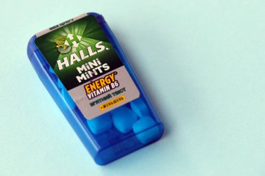 KYIV, UKRAINE - 20 Nisan 2024 Halls Mini nane şekeri bükülmüş enerji vitamini b6 küçük mavi kutu içinde sert nane şekerleri mavi arka planda yakın plan