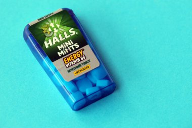 KYIV, UKRAINE - 20 Nisan 2024 Halls Mini nane şekeri bükülmüş enerji vitamini b6 küçük mavi kutu içinde sert nane şekerleri mavi arka planda yakın plan