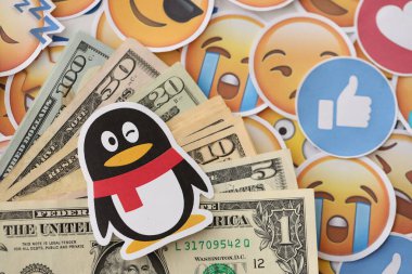 KYIV, UKRAINE - 20 Nisan 2024 Tencent QQ logosu ve pek çok kullanıcı para faturası. Birçok emoji reaksiyonuna ilişkin ünlü sosyal ağ platformu ve dolar banknotlarının sembolü