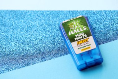 KYIV, UKRAINE - 20 Nisan 2024 Halls Mini nane şekeri bükülmüş enerji vitamini b6 küçük mavi kutu içinde sert nane şekerleri mavi arka planda yakın plan