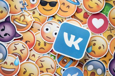 KYIV, UKRAINE - 20 Nisan 2024 VK logosu ve Emoji sarı yüzlü büyük çıkartmalar. Emoji, elektronik mesajlarda ve web sayfalarında kullanılan ve metne gömülü bir resim veya gülen yüzdür.