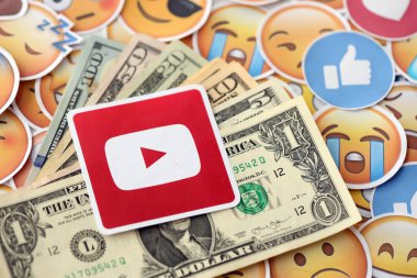 KYIV, UKRAINE - 20 Nisan 2024 YouTube logosu ve birçok kullanım dışı para. Birçok emoji reaksiyonuna ilişkin ünlü sosyal ağ platformu ve dolar banknotlarının sembolü