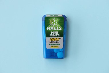 KYIV, UKRAINE - 20 Nisan 2024 Halls Mini nane şekeri bükülmüş enerji vitamini b6 küçük mavi kutu içinde sert nane şekerleri mavi arka planda yakın plan