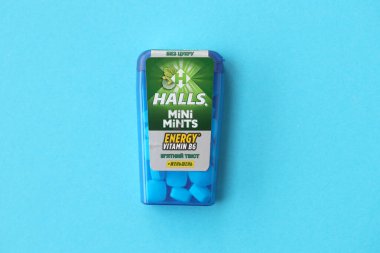KYIV, UKRAINE - 20 Nisan 2024 Halls Mini nane şekeri bükülmüş enerji vitamini b6 küçük mavi kutu içinde sert nane şekerleri mavi arka planda yakın plan