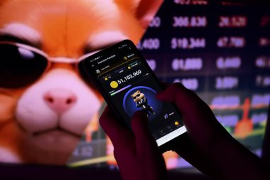 KYIV, UKRAINE - APRIL 20, 2024 Hamster Kombat telegram bot on smartphone screen. Hamster Kombat is a viral Telegram-based crypto game for earn HMSTR tokens by managing a virtual crypto exchange clipart