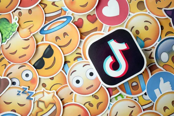stock image KYIV, UKRAINE - APRIL 20, 2024 TikTok logo and large set of stickers with Emoji yellow faces. Emoji is a pictogram or smiley embedded in text and used in electronic messages and web pages