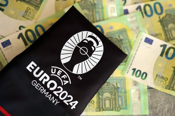 stock image KYIV, UKRAINE - APRIL 20, 2024 Official UEFA Euro 2024 Germany logotype on souvenir production and european money bills close up