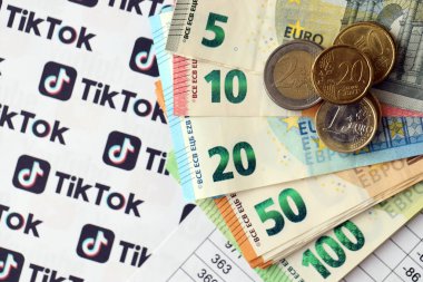 KYIV, UKRAINE - 20 Nisan, 2024 TikTok logosu ve bir sürü avro para. Ünlü sosyal ağ platformu ve Avrupa para birimi banknotlarının sembolü