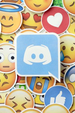 KYIV, UKRAINE - 20 Nisan 2024 Discord logosu ve Emoji sarı yüzlü büyük çıkartmalar. Emoji, elektronik mesajlarda ve web sayfalarında kullanılan ve metne gömülü bir resim veya gülen yüzdür.