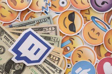KYIV, UKRAINE - 20 Nisan, 2024 Twitch logosu ve birçok kullanım parası. Birçok emoji reaksiyonuna ilişkin ünlü sosyal ağ platformu ve dolar banknotlarının sembolü