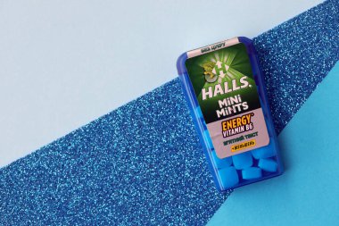 KYIV, UKRAINE - 20 Nisan 2024 Halls Mini nane şekeri bükülmüş enerji vitamini b6 küçük mavi kutu içinde sert nane şekerleri mavi arka planda yakın plan