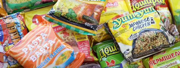 stock image KYIV, UKRAINE - APRIL 20, 2024 Many packs of instant noodles for fast cooking by various brands and manufacturers close up