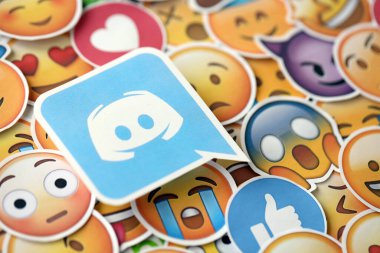 KYIV, UKRAINE - 20 Nisan 2024 Discord logosu ve Emoji sarı yüzlü büyük çıkartmalar. Emoji, elektronik mesajlarda ve web sayfalarında kullanılan ve metne gömülü bir resim veya gülen yüzdür.