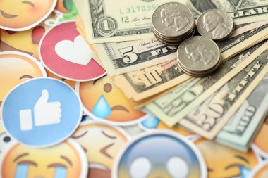 KYIV, UKRAINE - 20 Nisan 2024 dolar para ve Emoji sarı yüzlü büyük çıkartmalar. Sm kavramı, smo sosyal medyada yükseltmek için ödeme yaptı. Geribildirim ve ödenmiş sahte tepkiler