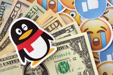 KYIV, UKRAINE - 20 Nisan 2024 Tencent QQ logosu ve pek çok kullanıcı para faturası. Birçok emoji reaksiyonuna ilişkin ünlü sosyal ağ platformu ve dolar banknotlarının sembolü