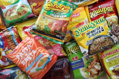 KYIV, UKRAINE - APRIL 20, 2024 Many packs of instant noodles for fast cooking by various brands and manufacturers close up clipart