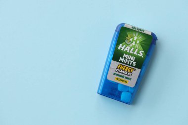 KYIV, UKRAINE - 20 Nisan 2024 Halls Mini nane şekeri bükülmüş enerji vitamini b6 küçük mavi kutu içinde sert nane şekerleri mavi arka planda yakın plan