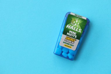 KYIV, UKRAINE - 20 Nisan 2024 Halls Mini nane şekeri bükülmüş enerji vitamini b6 küçük mavi kutu içinde sert nane şekerleri mavi arka planda yakın plan