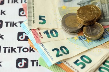 KYIV, UKRAINE - 20 Nisan, 2024 TikTok logosu ve bir sürü avro para. Ünlü sosyal ağ platformu ve Avrupa para birimi banknotlarının sembolü