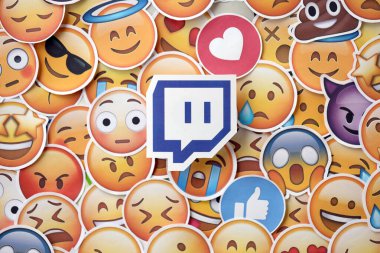 KYIV, UKRAINE - 20 Nisan 2024 Twitch logosu ve Emoji sarı yüzlü büyük çıkartmalar. Emoji, elektronik mesajlarda ve web sayfalarında kullanılan ve metne gömülü bir resim veya gülen yüzdür.