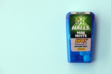 KYIV, UKRAINE - 20 Nisan 2024 Halls Mini nane şekeri bükülmüş enerji vitamini b6 küçük mavi kutu içinde sert nane şekerleri mavi arka planda yakın plan