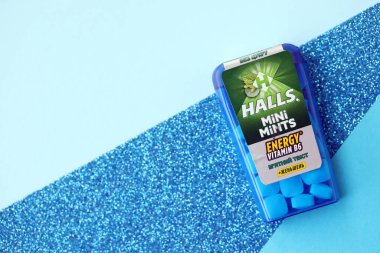 KYIV, UKRAINE - 20 Nisan 2024 Halls Mini nane şekeri bükülmüş enerji vitamini b6 küçük mavi kutu içinde sert nane şekerleri mavi arka planda yakın plan
