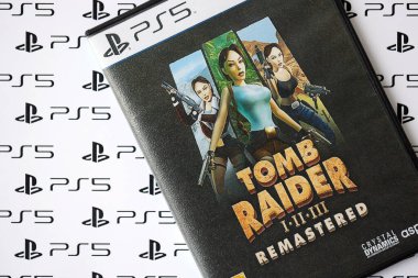 KYIV, UKRAINE - 26 Haziran 2024 Tomb Raider 1-2-3 Konsol oyunu için PS5 oyun diski kutusunda ustalaştı. Popüler video oyunu diski kapat