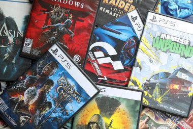 KYIV, UKRAINE - 26 Haziran 2024 Sony Playstation 5 ve 4 konsolu için video oyunları yığını. Birçok popüler video oyunu disk kutusu kapanıyor