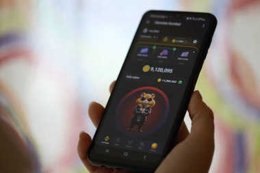 KYIV, UKRAINE - 26 Haziran 2024 Hamster Kombat mini telgraf oyunu. Akıllı telefondaki tıkırtı oyunu elinizin altında